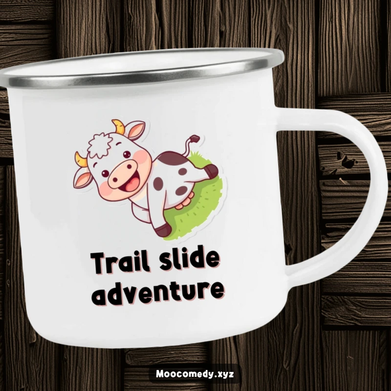 Funny camping mug depicting a happy cow with a grin sliding down a grassy hill in a rustic setting.